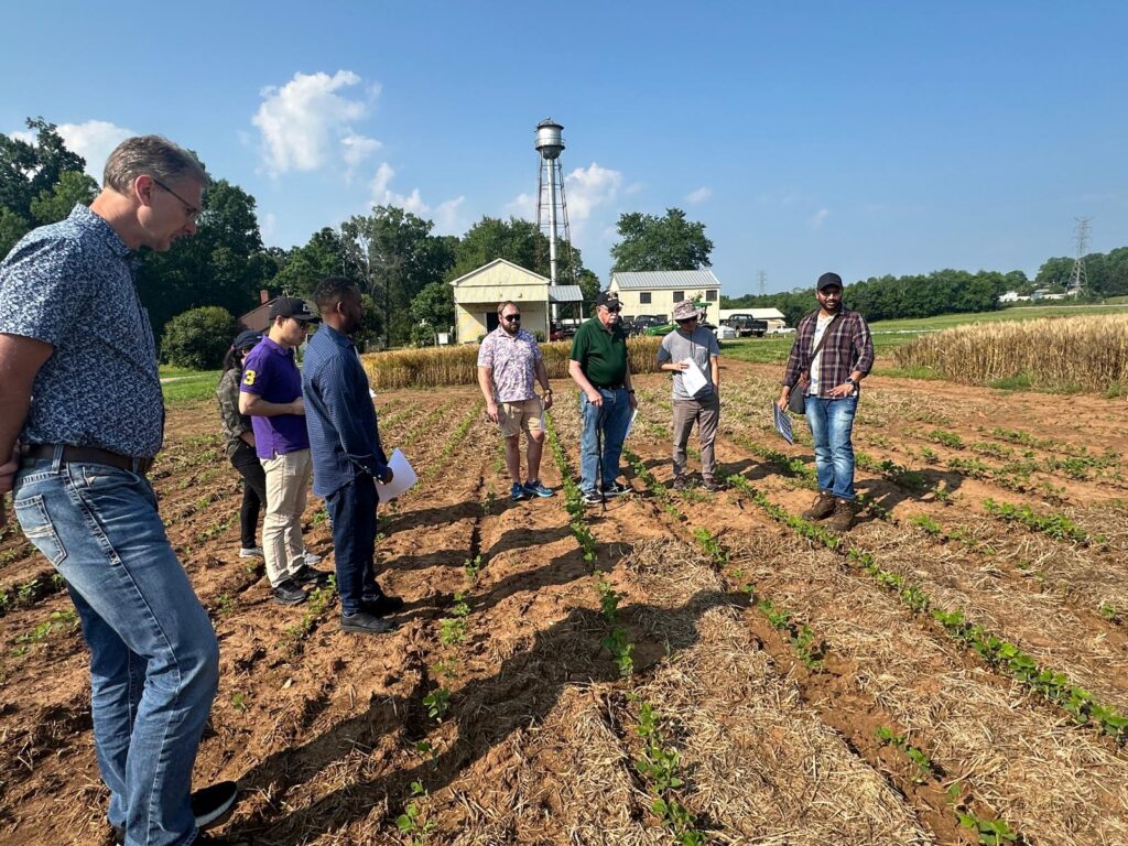 The photo features Dr. Neelipally presenting the double crop project to the NC1178 Multi-State Project Team.
