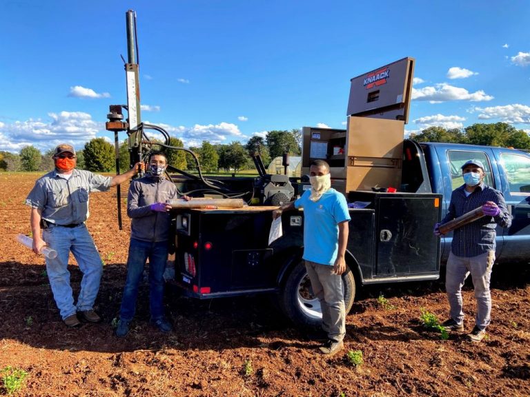 Researchers pictured with hydraulic probe in the field.