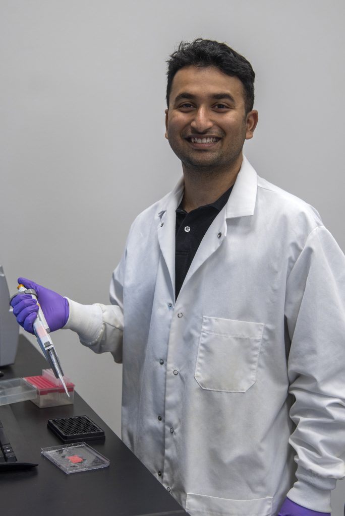 PhD candidate Rounak Patra photo taken in the lab with a sample.