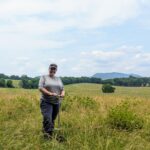Amber poses with a soil probe while collecting soil samples for her master's. work.